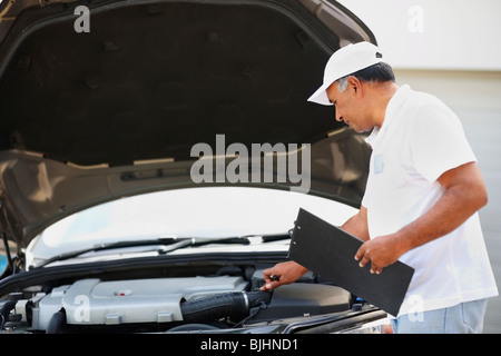 Men mechanics checking an engine of a car at a pit lane. Kyiv, Ukraine ...
