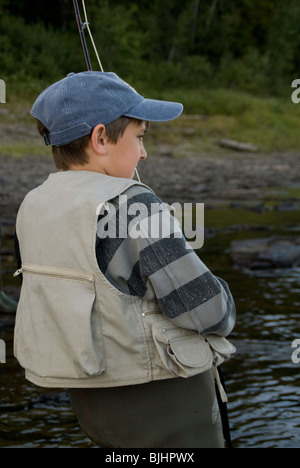 Zachary Colford,12,plays a large Atlantic salmon on the Miramichi River where his father is a guide. Stock Photo