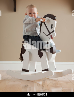 Baby on rocking horse Stock Photo