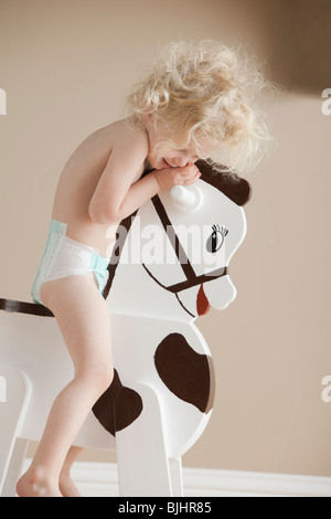 Toddler on rocking horse Stock Photo