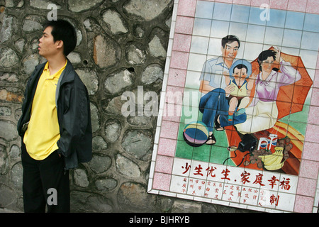 A tiled mural in a Guangzhou street advocates 'happy families', and China's 'one child' policy for families, China. Stock Photo