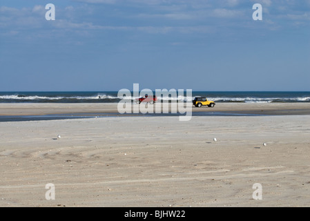 Two four-wheel drive vehicles on public beach. Stock Photo