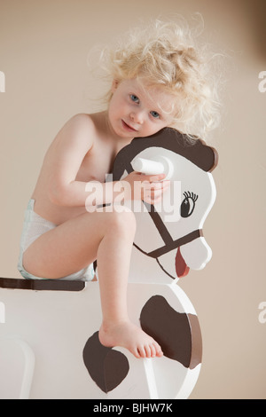 Toddler on rocking horse Stock Photo
