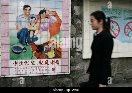 A tiled mural in a Guangzhou street advocates 'happy families', and China's 'one child' policy for families, China. Stock Photo