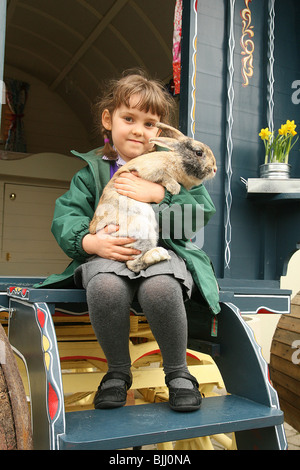 girl holding rabbit in Gypst Caravan Stock Photo