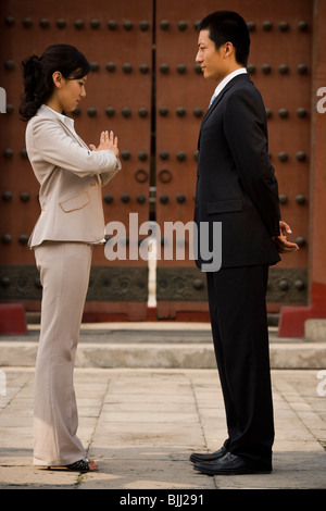 Businesswoman and man facing each other in greeting outdoors Stock Photo