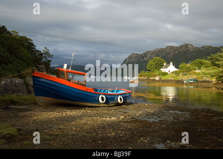 Clinker built wooden boat, with a red cover, on the ...