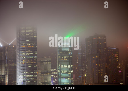 Office blocks lit up at night in Hong Kong, China. This densely populated city has a massive carbon footprint. Stock Photo