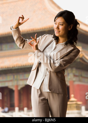 Businesswoman doing tai chi outdoors smiling Stock Photo