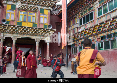 Young novice monks playing with a ball in the courtyard of a monastery in a small village in Aba in Sichuan in China. Stock Photo