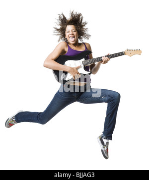 Girl with braces and guitar leaping and sticking tongue out Stock Photo