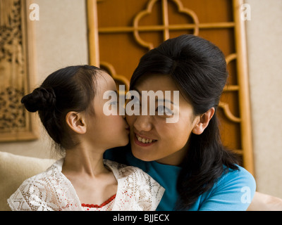 Mother giving daughter a kiss on cheek Stock Photo