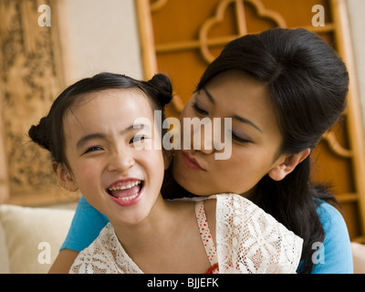 Mother giving daughter a kiss on cheek Stock Photo