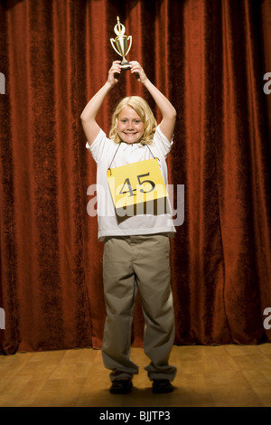 Girl contestant holding trophy and smiling Stock Photo