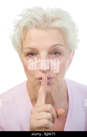 Woman, 60, holding her finger to her lips Stock Photo