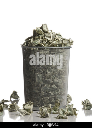 Waste paper basket with crumpled money Stock Photo