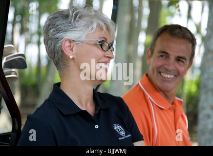 Smiling senior couple in golf cart on golf course Stock Photo