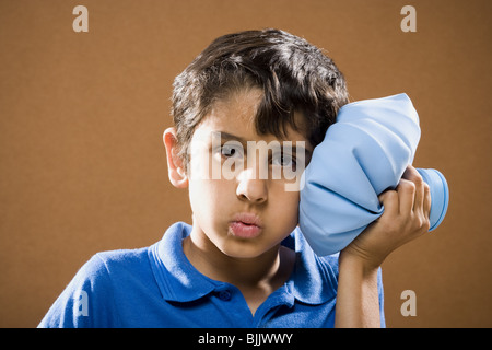 Boy holding ice pack to head Stock Photo