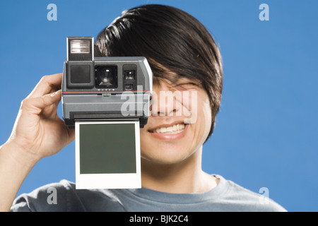 Man with instant camera and blank photo Stock Photo