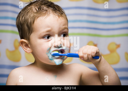 Boy brushing teeth in bathroom Stock Photo