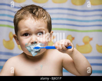 Boy brushing teeth in bathroom Stock Photo