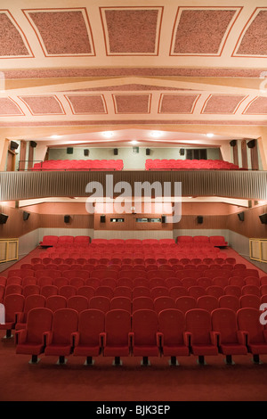 Interior of retro cinema auditorium with balcony in cubism style with line of chairs. Stock Photo