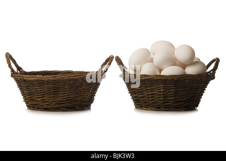 One empty basket and one filled with eggs Stock Photo