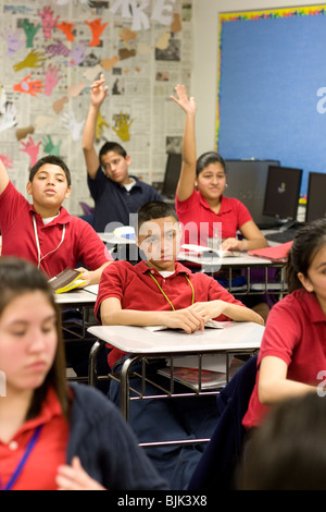 High school students raise hands to answer questions in classroom at Peak Preparatory Academy, a public high school in Dallas, Texas Stock Photo