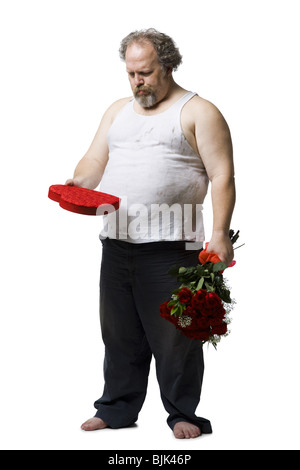 Disheveled man with red roses and heart box frowning Stock Photo