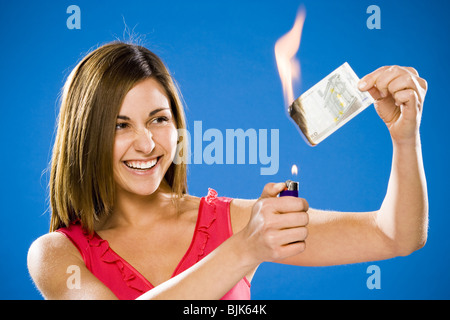 Woman setting American one dollar bill on fire Stock Photo