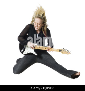 Woman jumping with electric guitar