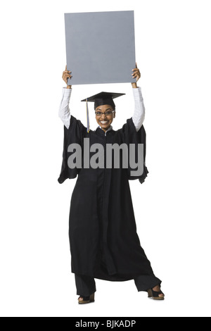 Woman in graduation gown and Blank Sign with blank sign Stock Photo