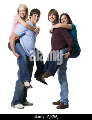 Two boys giving two girls piggy back rides Stock Photo