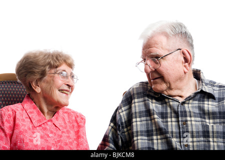 Elderly couple in armchairs holding hands Stock Photo