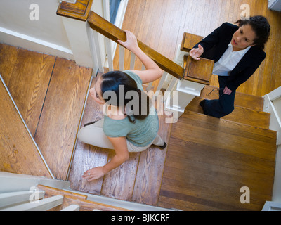 Two women arguing on staircase Stock Photo