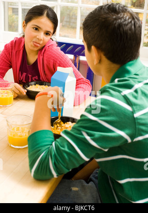 Girl sticking tongue out at breakfast table Stock Photo