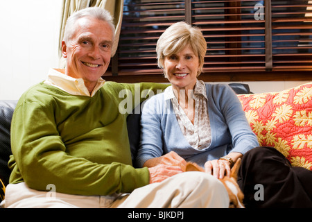 Mature couple cuddling on sofa Stock Photo