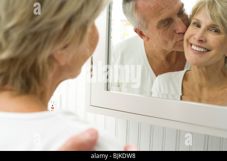 Reflection of mature couple kissing in mirror Stock Photo