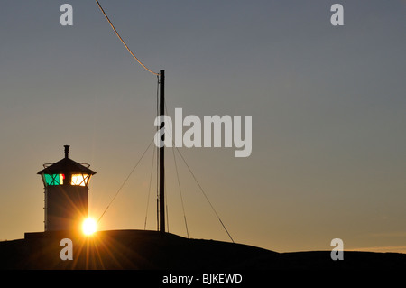 Sun Setting Behind a Lighthouse Stock Photo