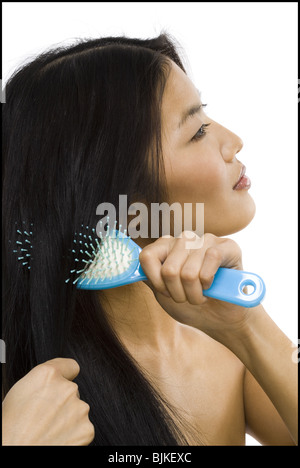 Smiling woman brushing hair Stock Photo