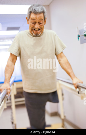 Older man with one leg exercising and smiling Stock Photo