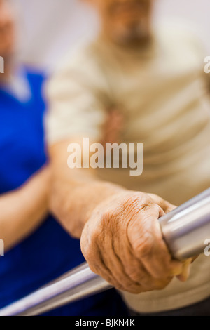 Physical Therapist holding a patient while walking Stock Photo