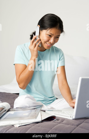 Woman on bed with laptop Stock Photo