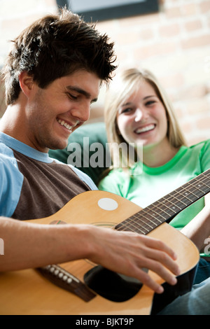 Man singing with guitar for woman Stock Photo