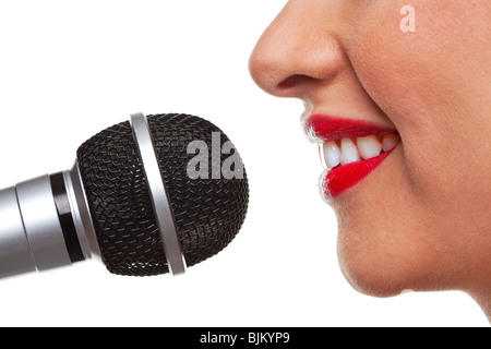 Close up of a woman using a microphone, isolated on a white background. Stock Photo