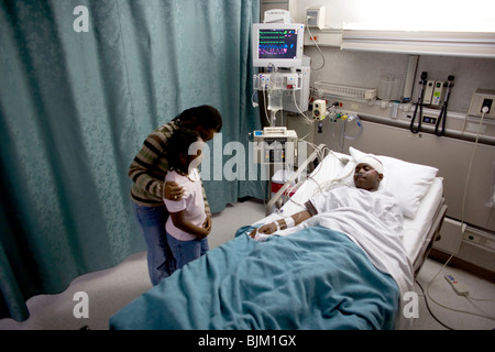 Parents with boy in hospital bed wearing head bandages Stock Photo