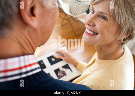 Rear view of mature couple with photo album Stock Photo