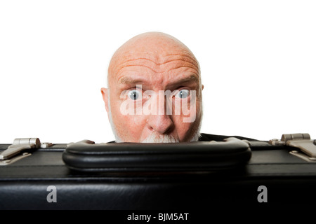 Mature man hiding behind briefcase Stock Photo