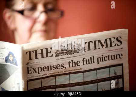 Woman reading a copy of The Times newspaper with the headline. Expenses, the full picture. Stock Photo