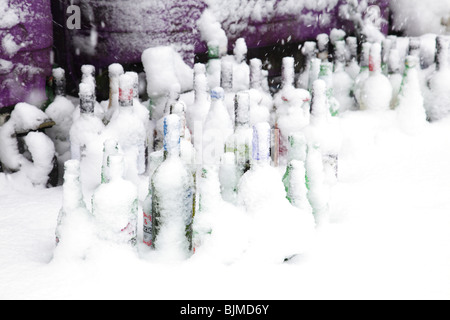 Glass bottles waiting to be collected from a recycling point in winter snow, Scotland, UK Stock Photo